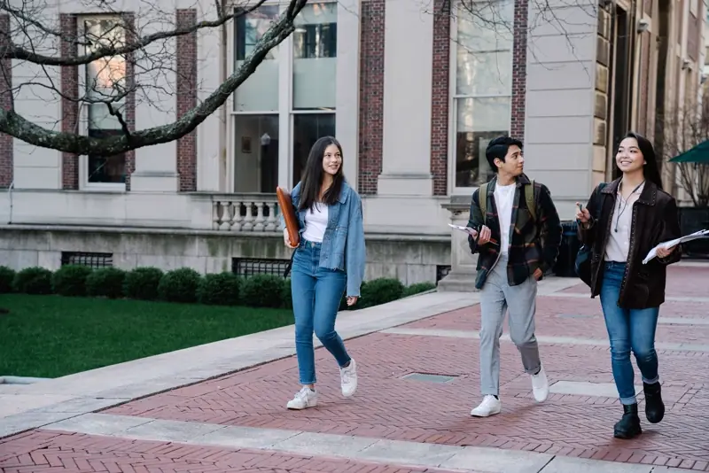 Students walking across a university campus between classes