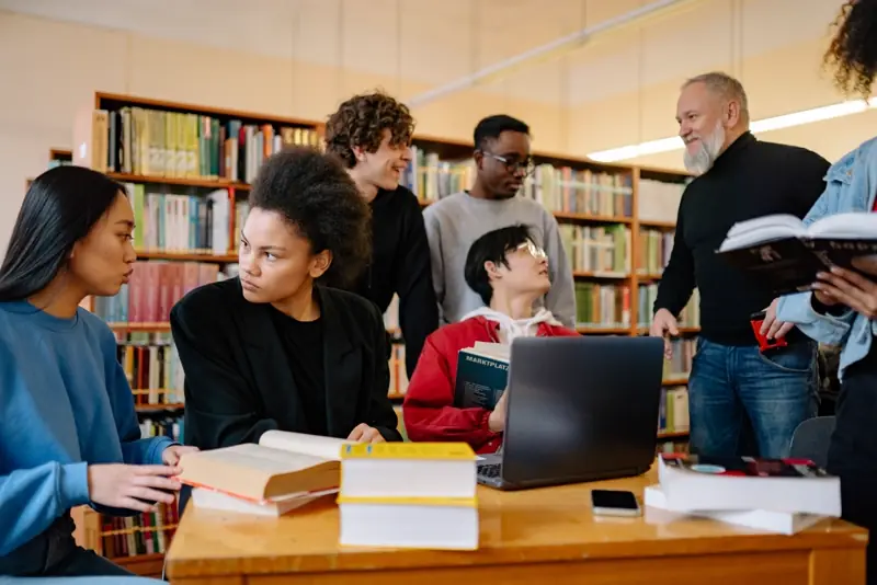 Students comparing course information together in a university library